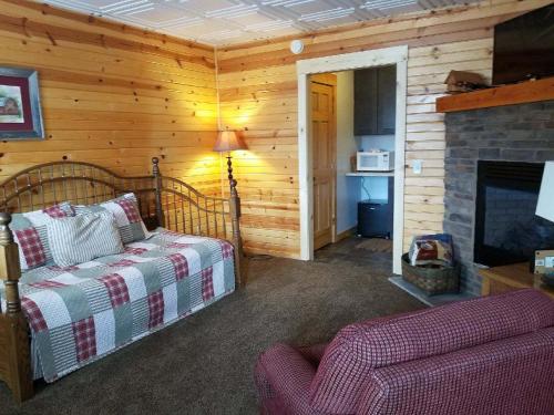 a living room with a bed and a fireplace at Amish Blessings Cabins in Millersburg