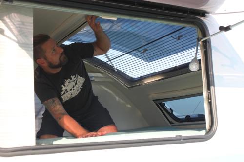 Mężczyzna patrzy przez okno samochodu. w obiekcie Sandbank2go w mieście Cuxhaven