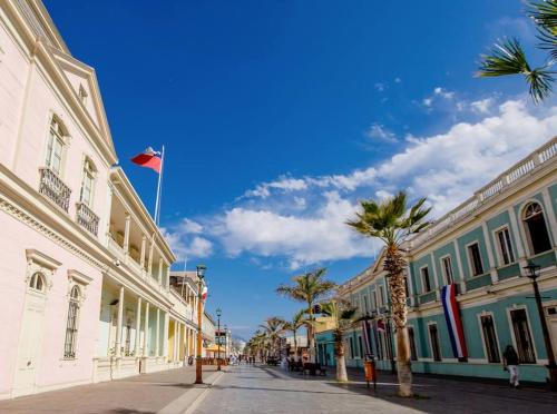 una calle con palmeras y una cometa en un edificio en Hostal Aloha Inn, en Iquique