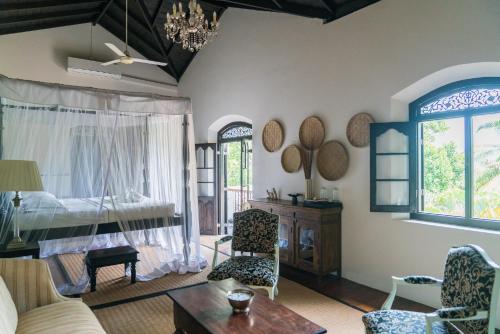 a living room with a bed and a table at Galle Henna Estate in Unawatuna