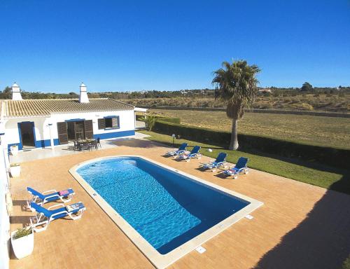 een zwembad met ligstoelen en een huis bij Villa Sardenha by Algarve Vacation in Guia