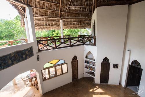 a room with white walls and a large window at Casa Umoja in Nungwi