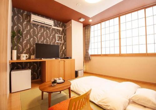 a bedroom with a bed and a table and a tv at Arakawa-ku - Hotel / Vacation STAY 21943 in Tokyo