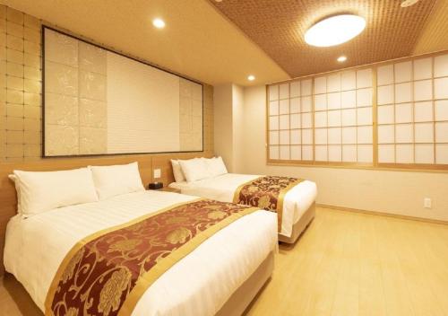東京にあるArakawa-ku - Hotel / Vacation STAY 22245のベッド2台と大画面テレビが備わる客室です。