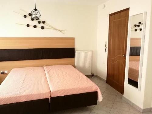 a bedroom with a large bed with a pink blanket at Iliana's house in Naousa Imathias