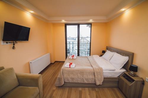 une chambre avec un lit, un canapé et une télévision dans l'établissement New Gudauri Loft 2 #557, à Goudaouri
