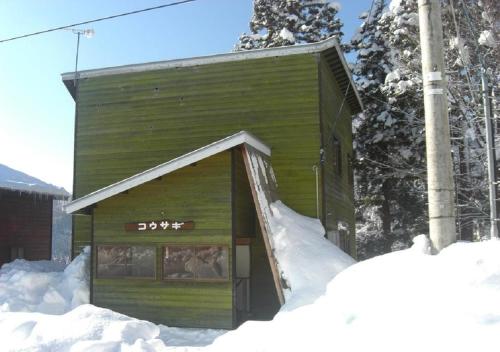 妙高的住宿－Myoko - Hotel / Vacation STAY 22314，一座绿色的小建筑,在雪中设有斜坡