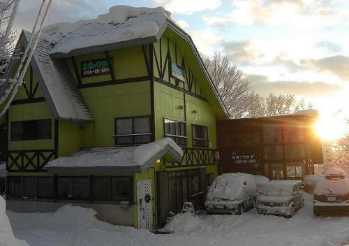 妙高的住宿－Myoko - Hotel / Vacation STAY 22314，一座雪覆盖的房子,前面停有汽车