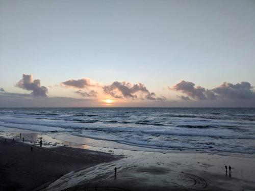 a sunset over the ocean with people on the beach at Seagull Beachfront Inn in Lincoln City