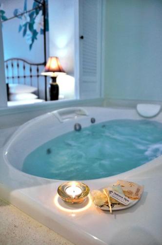 a jacuzzi tub with a candle and a candle at Ping Nakara Boutique Hotel And Spa in Chiang Mai