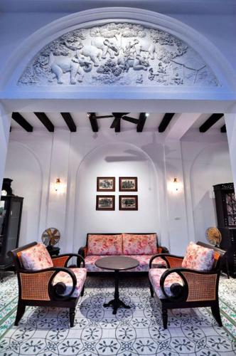 a living room with a couch and chairs and a table at Ping Nakara Boutique Hotel And Spa in Chiang Mai