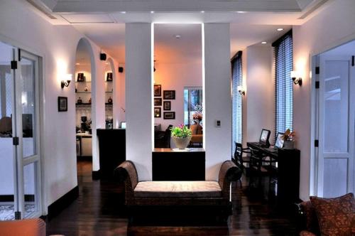 a living room with a couch and a table and chairs at Ping Nakara Boutique Hotel And Spa in Chiang Mai