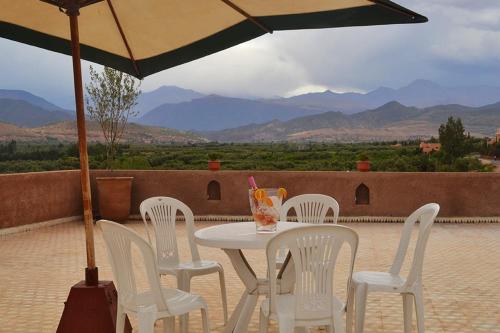 a table and chairs with an umbrella on a patio at Villa Paradise in Aghmat