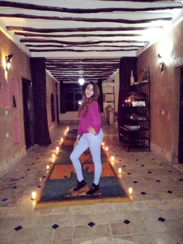 a woman standing on a rug in a room with lights at Villa Paradise in Aghmat