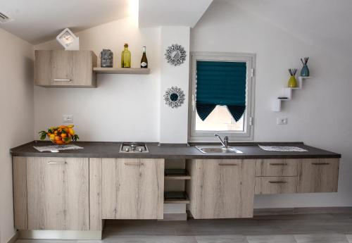 a kitchen with a counter with a sink and a window at Casa Belvedere in Agrigento