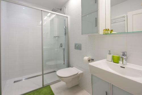 Baño blanco con aseo y lavamanos en Nije Preša Apartments, en Dubrovnik