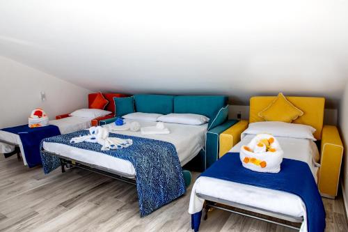 um quarto com três camas e duas mesas em Casa Belvedere em Agrigento