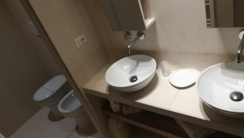 a bathroom with two sinks and a toilet at B&B Dimora Damiani in Montefiore dellʼAso