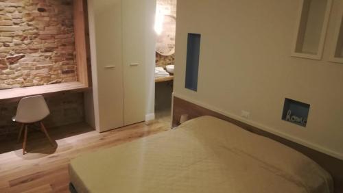 a bedroom with a bed and a chair in a room at B&B Dimora Damiani in Montefiore dellʼAso