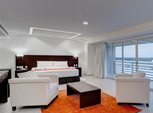 een slaapkamer met een bed en 2 stoelen en een tafel bij Hotel Yes Inn Nuevo Veracruz in Veracruz