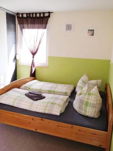 a bedroom with a wooden bed with pillows and a window at Ferienhaus Bielenski in Blankenburg