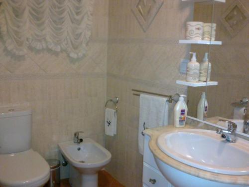 een badkamer met een wastafel en een toilet bij Condomínio do Mar in Lagos