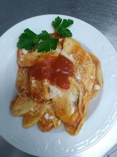 a plate of pasta with sauce and parsley on it at Hotel La Congiura dei Baroni in Teggiano