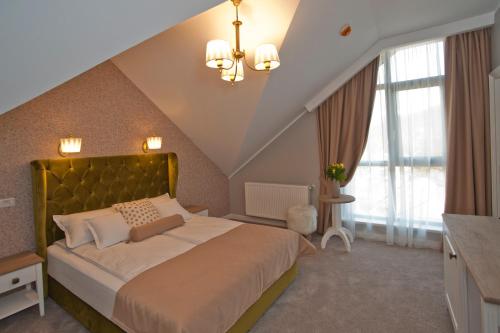 a bedroom with a large bed with a large window at Uphill Residence in Sinaia
