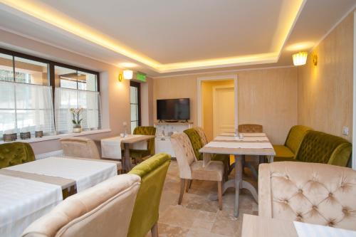 a restaurant with tables and chairs and a tv at Uphill Residence in Sinaia