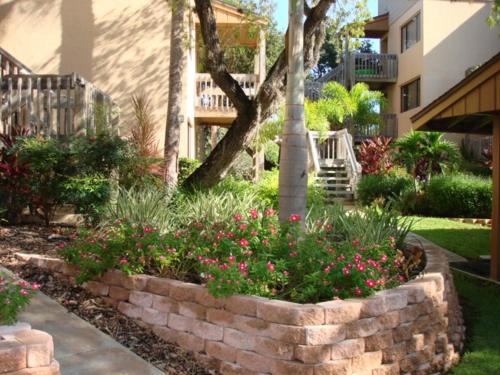 a retaining wall in a yard with flowers at Midnight Cove #714, Bayside in Siesta Key, FL in Siesta Key