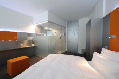 a bedroom with a large bed and a bathroom at Scala Turm Hotel Restaurant in Jena