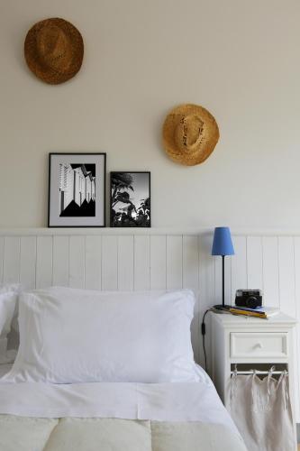 a bedroom with a white bed and three pictures on the wall at Casali Marchigiani - Ville vacanza private con piscina in Ostra