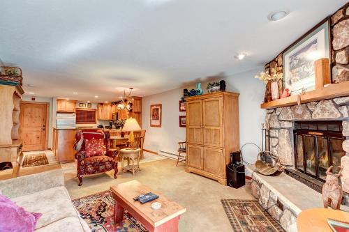 布雷肯里奇Atrium Bluebird Condo: Great Downtown Breck Location的客厅设有石制壁炉和桌子。