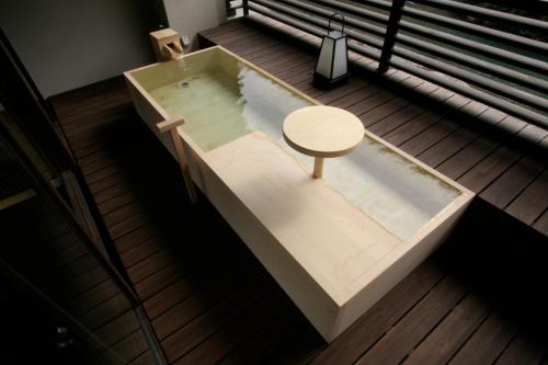 a bath tub with a table in the middle at Kawayu Onsen Fujiya in Hongu