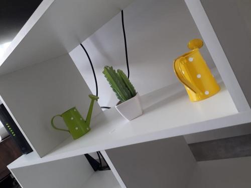 a white shelf with a yellow vase and a plant at Apartamento Uriburu-Con Cochera in Formosa