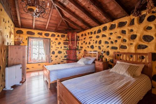 ブエナビスタ・デル・ノルテにあるCiruelo - Paz y senderos en área natural protegida de Tenoのベッド2台 木製の壁の部屋