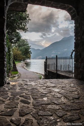 a stone walkway with a gate next to a body of water at Casa MICHI in Dervio