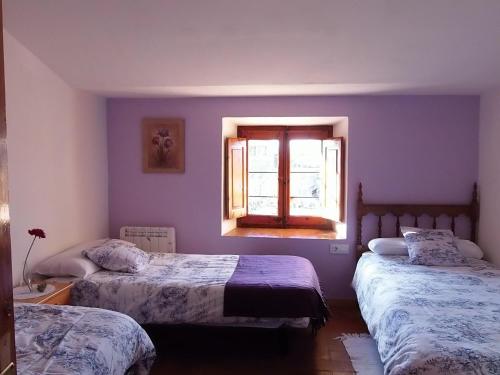 een slaapkamer met 2 bedden en een raam bij Rectoria de Montclar- habitatge d'ús turístic -apartament in Montclar
