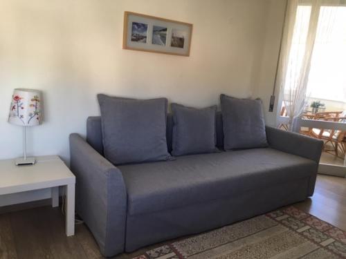 a blue couch in a living room with a table at Casa Mar in Costa da Caparica