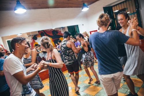 a large group of people standing around in a room at Viajero Hostel Cali & Salsa School in Cali