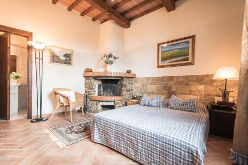 a bedroom with a bed and a stone fireplace at Podere San Martino in Montevettolini