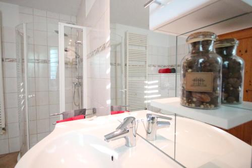 ein Badezimmer mit einem Waschbecken und einer Flasche auf dem Spiegel in der Unterkunft Ferienwohnung An den Tannen in Bartelshagen