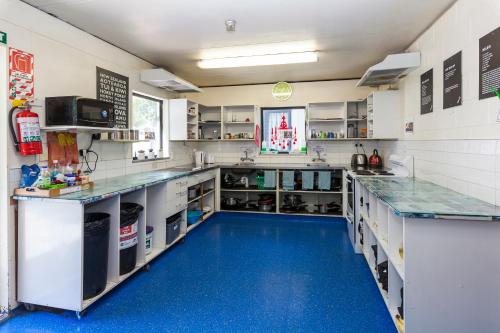 a large kitchen with a blue floor in the middle at Around The World Backpackers in Christchurch