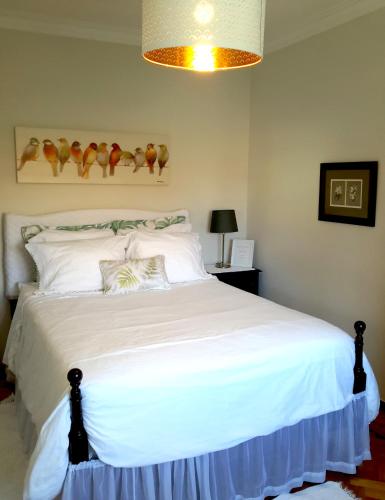 a bedroom with a bed with white sheets and a lamp at Kika room Estoril in Estoril