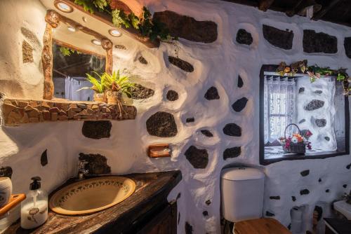 ブエナビスタ・デル・ノルテにあるCiruelo - Paz y senderos en área natural protegida de Tenoの石壁のバスルーム(シンク、鏡付)
