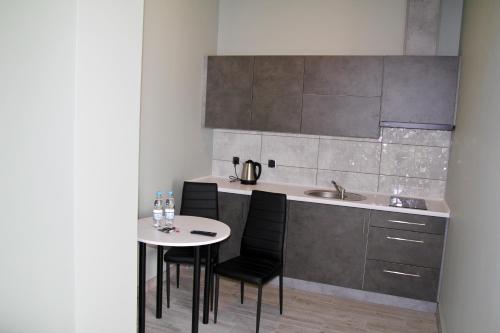 kuchnia ze stołem, krzesłami i zlewem w obiekcie Motel Lunar w Oświęcimiu