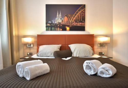 a bedroom with a bed with towels on it at Hotel Bürgerhof in Cologne