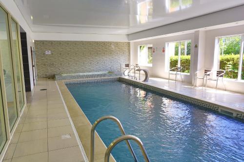 a swimming pool in a building with a swimming pool at Mercure Newcastle George Washington Hotel Golf & Spa in Newcastle upon Tyne