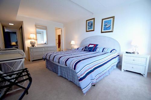 een slaapkamer met een groot bed en een gestreepte deken bij Ocean Hideaway 211 in Ocean City