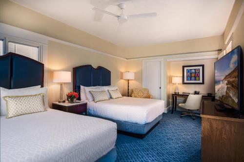 a hotel room with two beds and a television at Grande Colonial La Jolla in San Diego